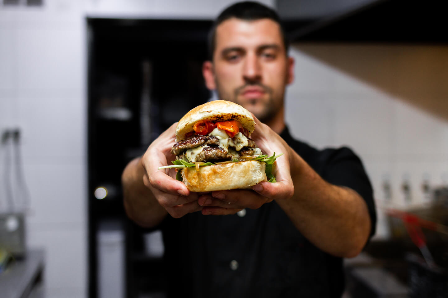 Man holding up a juicy burger